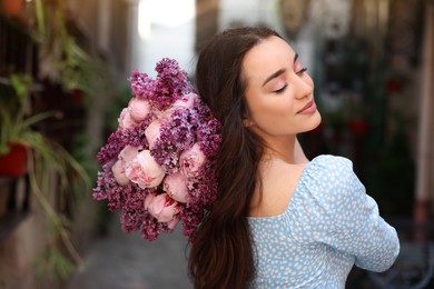 Photo of Beautiful woman with bouquet of spring flowers outdoors