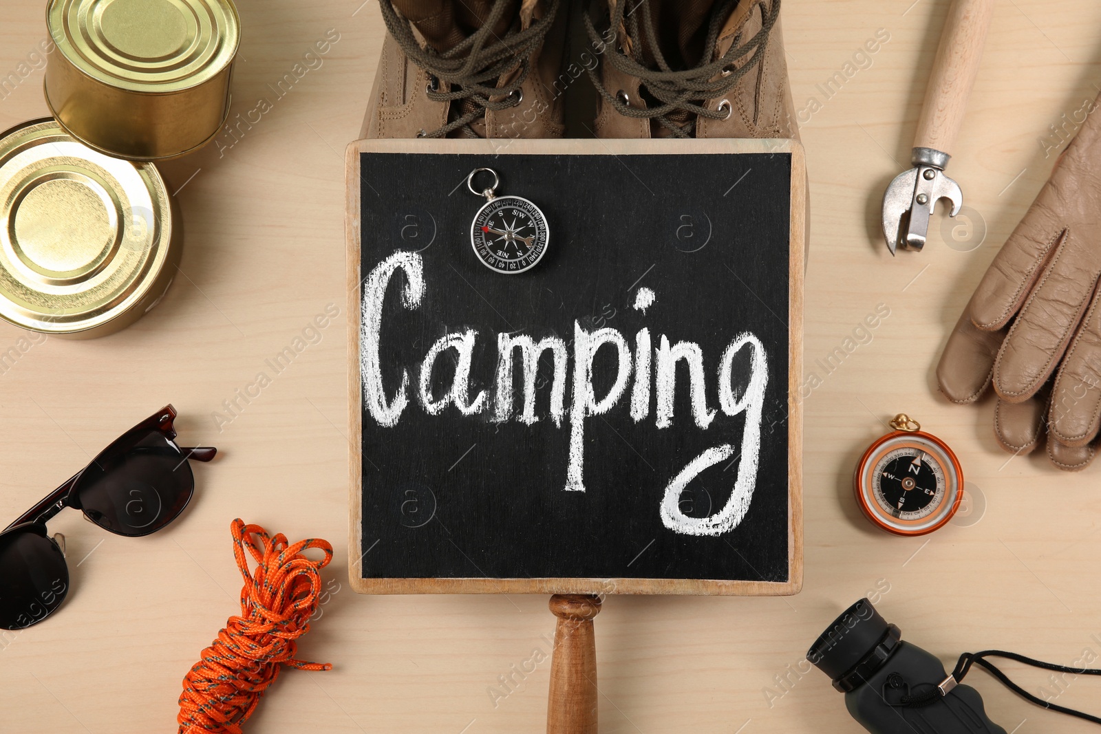 Photo of Flat lay composition with camping equipment on wooden background