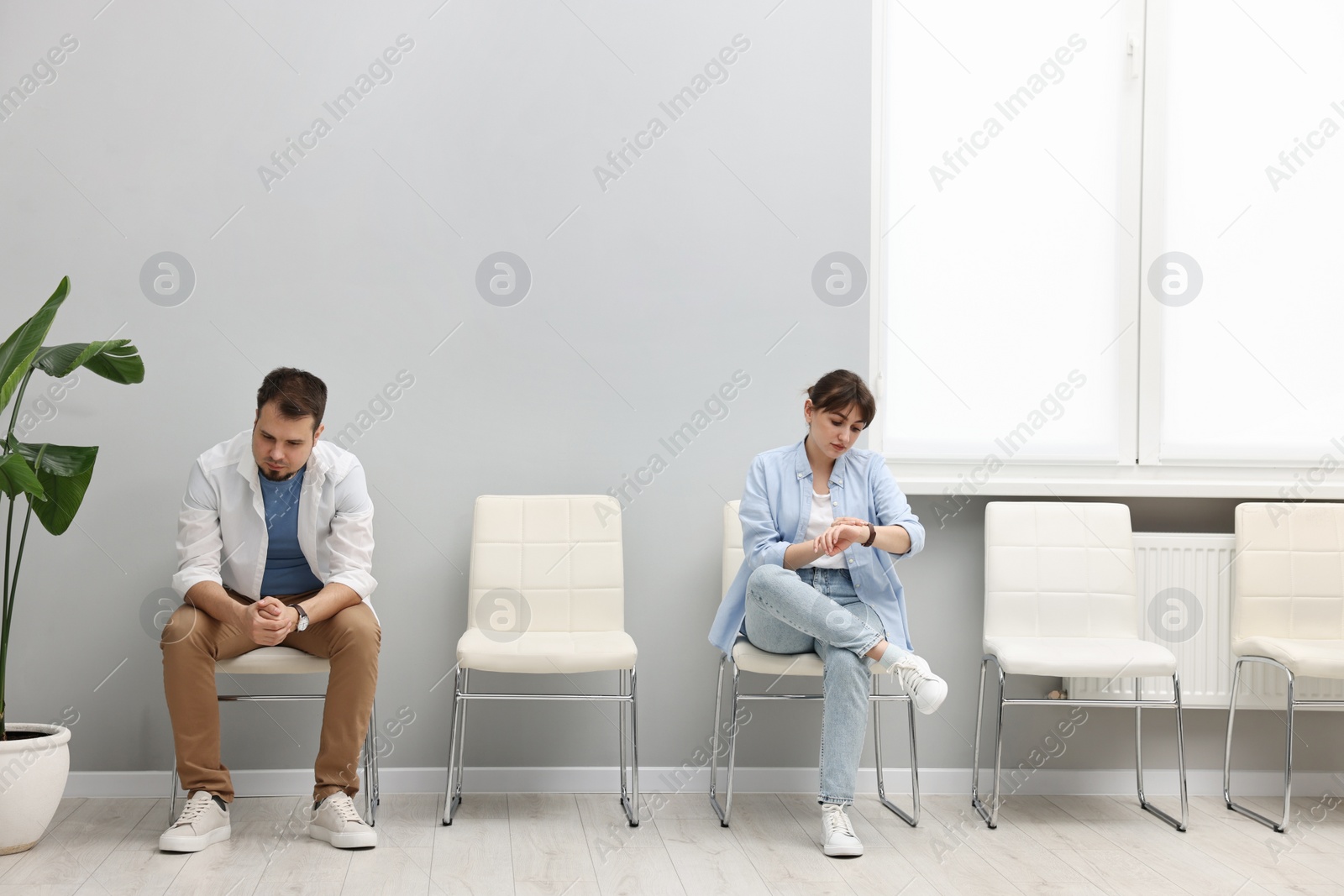 Photo of Man and woman waiting for appointment indoors