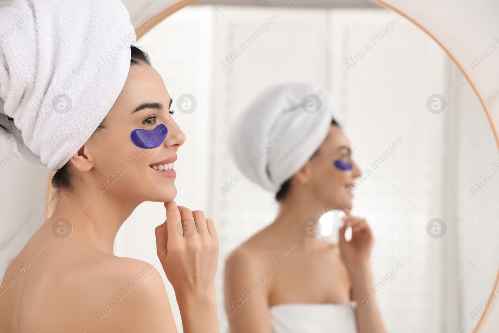 Photo of Beautiful young woman with under eye patches at home, space for text