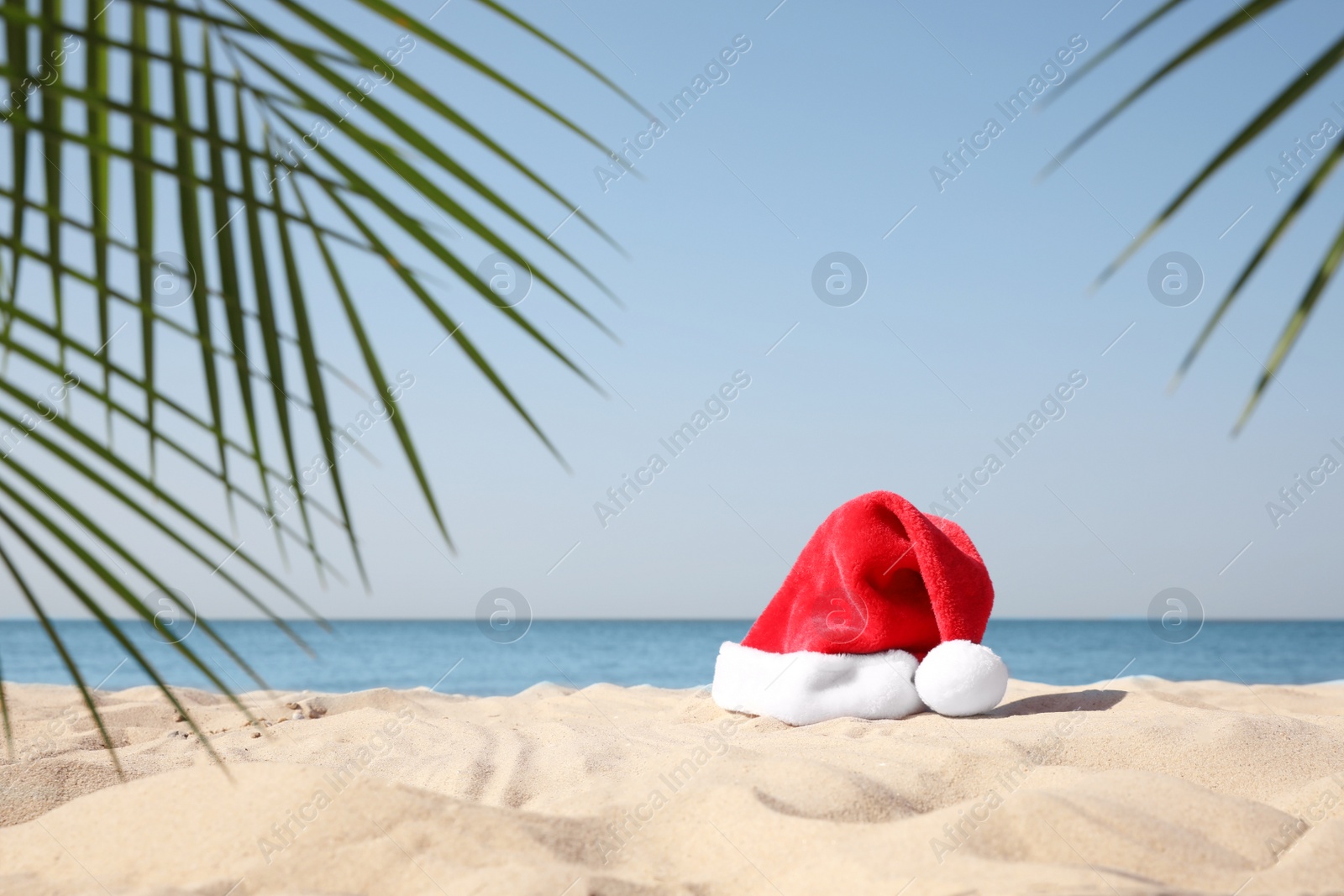 Photo of Santa's hat on sandy beach. Christmas vacation