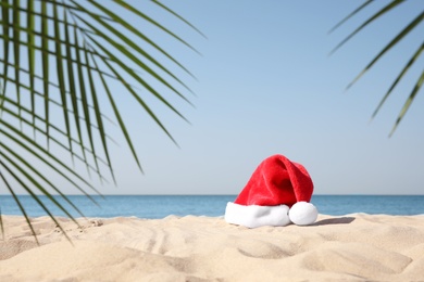 Photo of Santa's hat on sandy beach. Christmas vacation