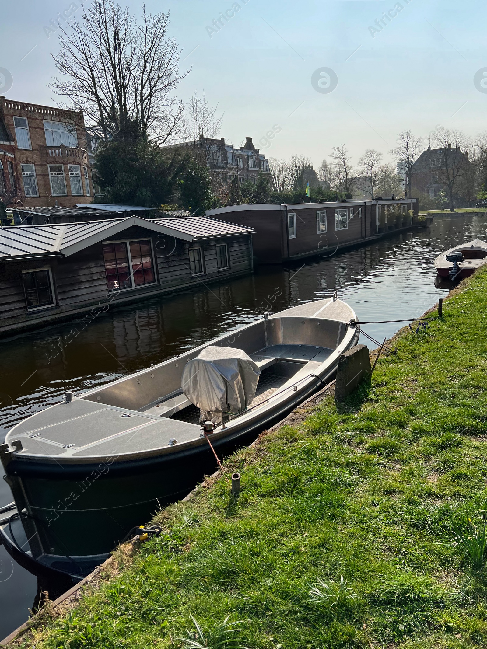 Photo of Beautiful city canal with moored boat on sunny spring day