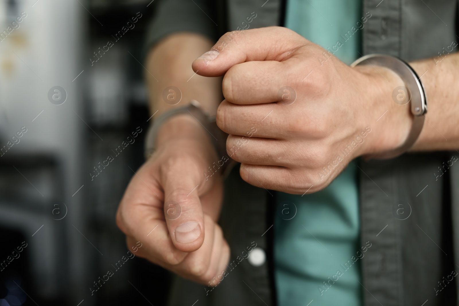 Photo of Man detained in handcuffs indoors, closeup view. Criminal law