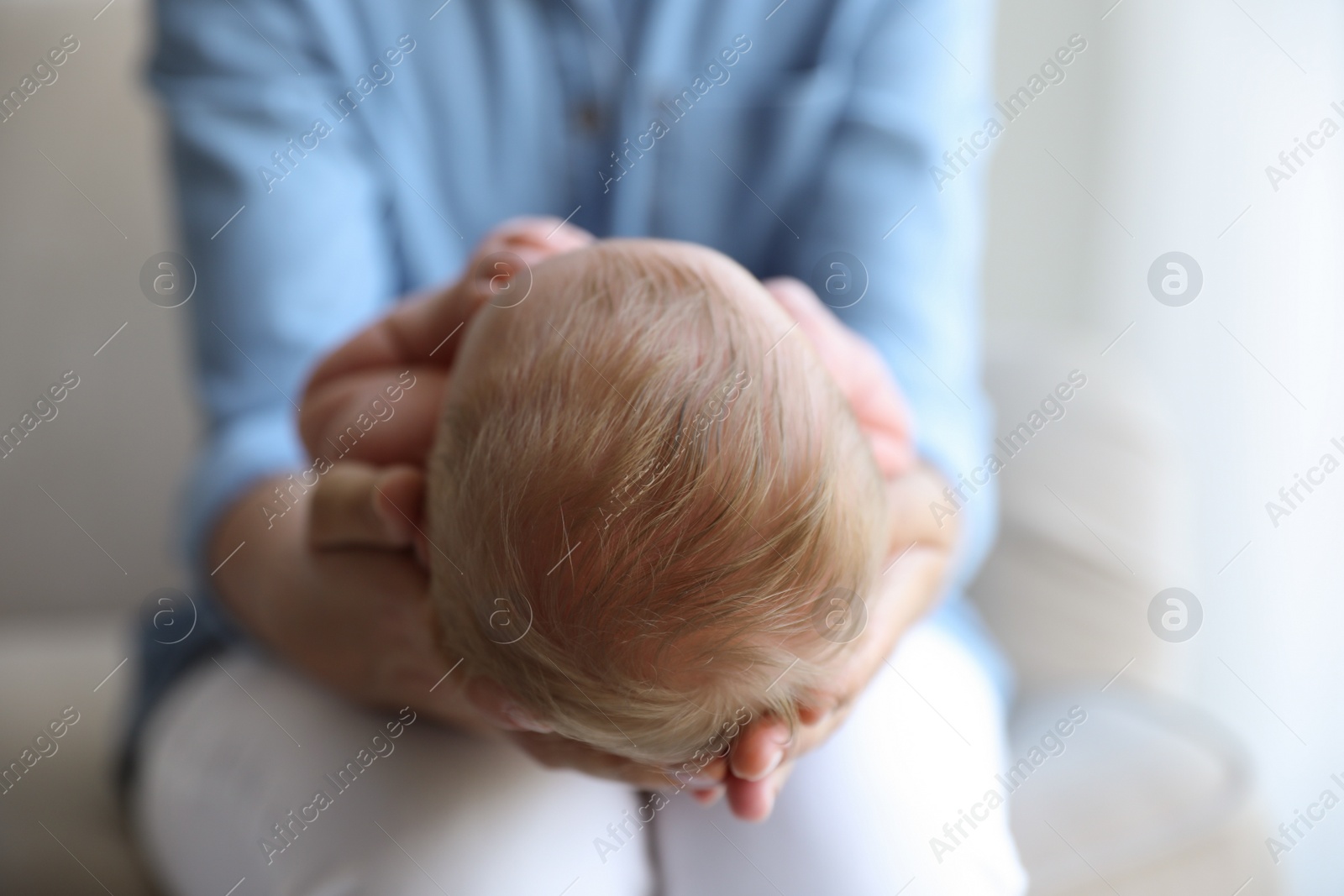 Photo of Mother holding her newborn baby at home, closeup