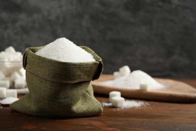 Photo of Granulated sugar in sack on wooden table. Space for text