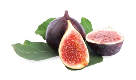 Fresh juicy purple figs and green leaves on white background