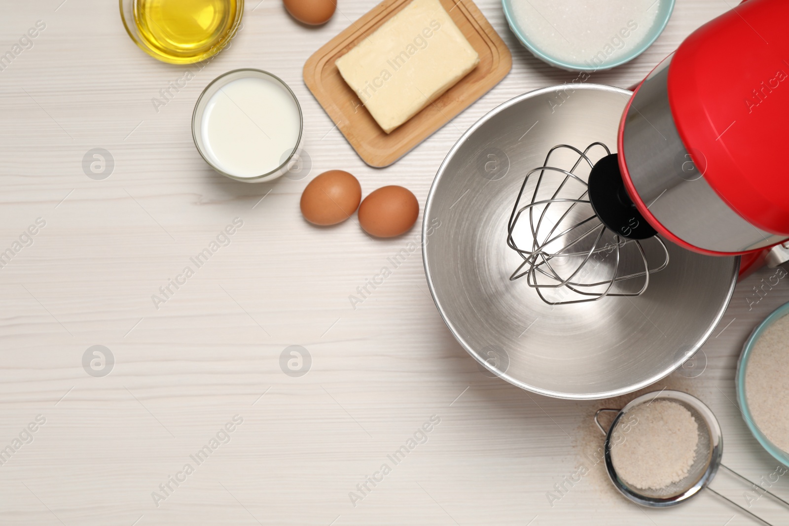 Photo of Modern red stand mixer and different ingredients on white wooden table, flat lay. Space for text