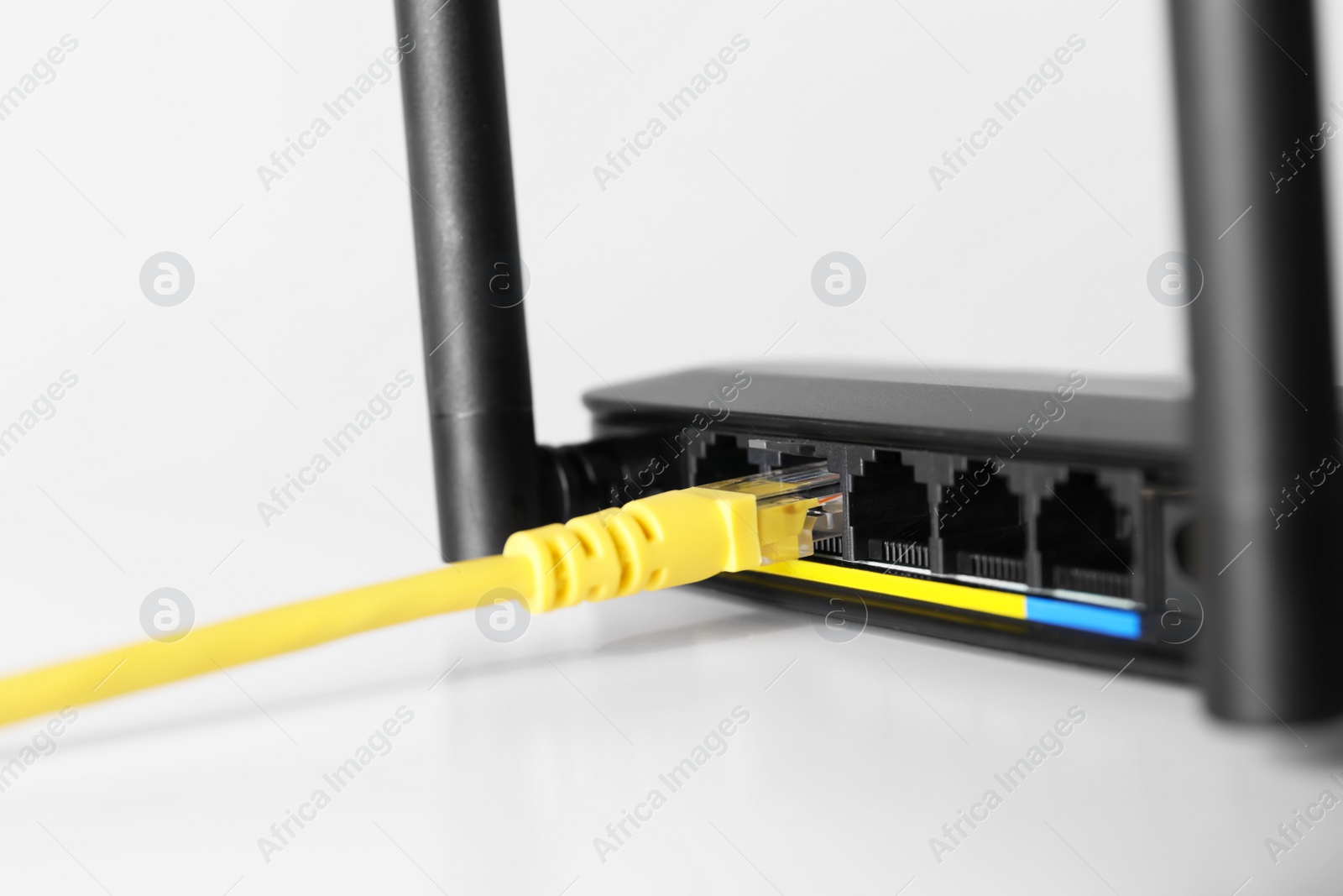 Photo of Connected cable to router on white table, closeup. Wireless internet communication