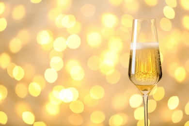 Photo of Glass of champagne against blurred lights. Space for text