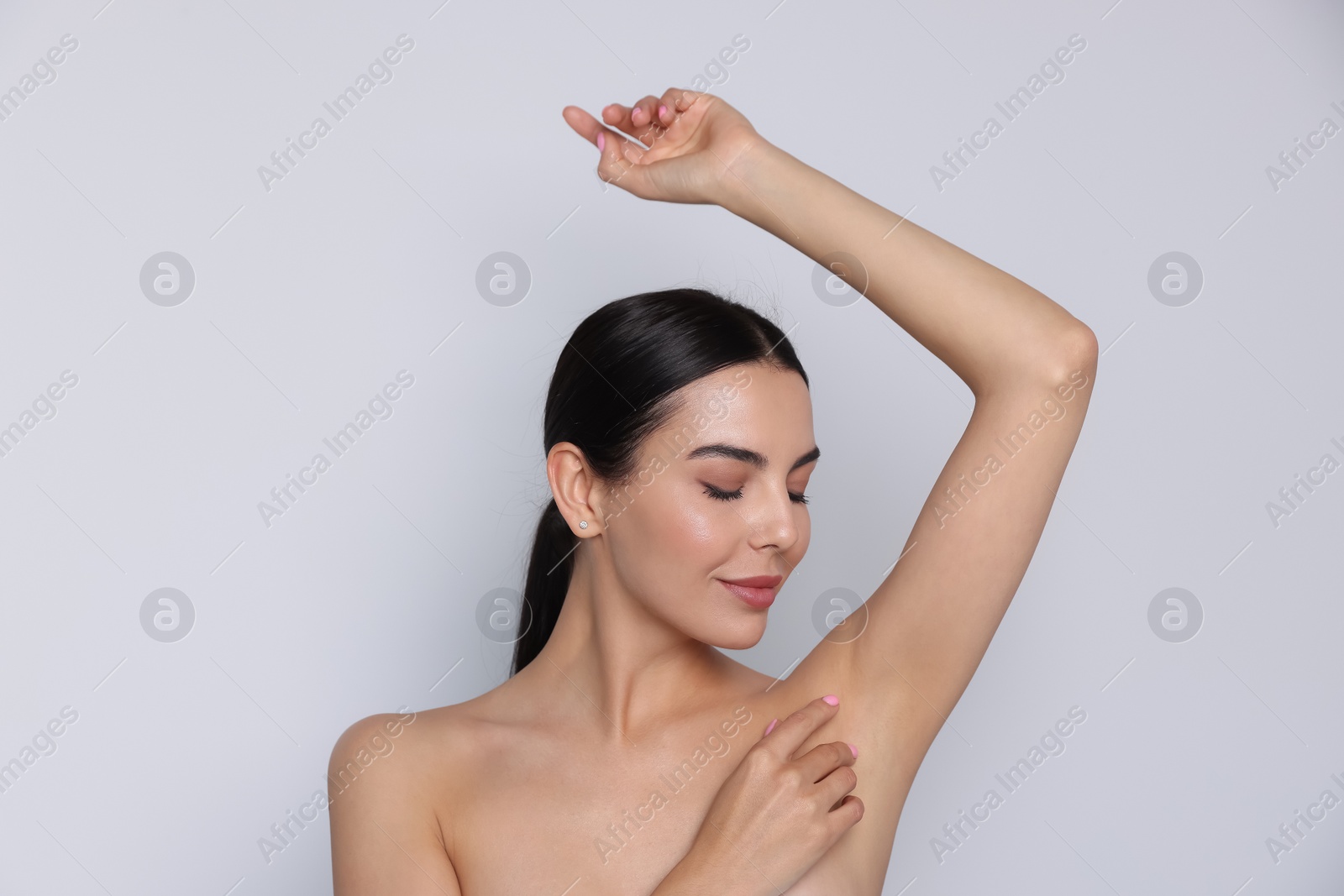 Photo of Young woman showing smooth skin after epilation on white background