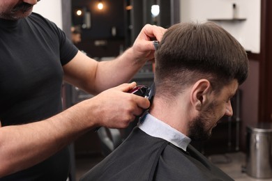 Professional hairdresser making stylish haircut in barbershop