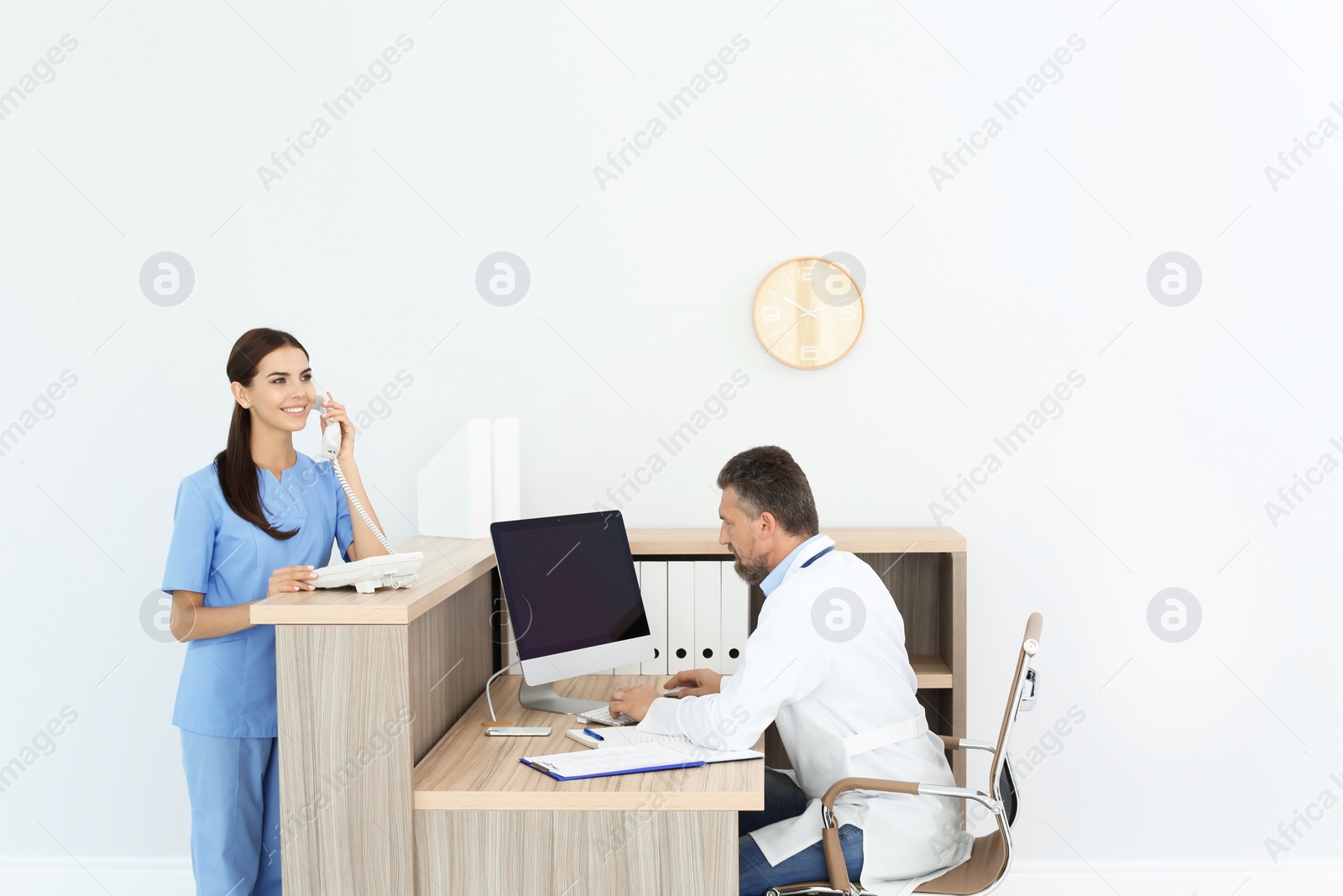 Photo of Doctor and medical assistant working in clinic. Health care service