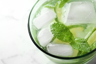 Refreshing beverage with mint and lime in glass, closeup