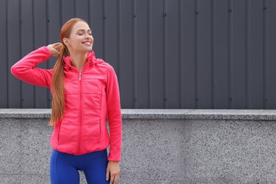 Photo of Beautiful woman in gym clothes on street, space for text