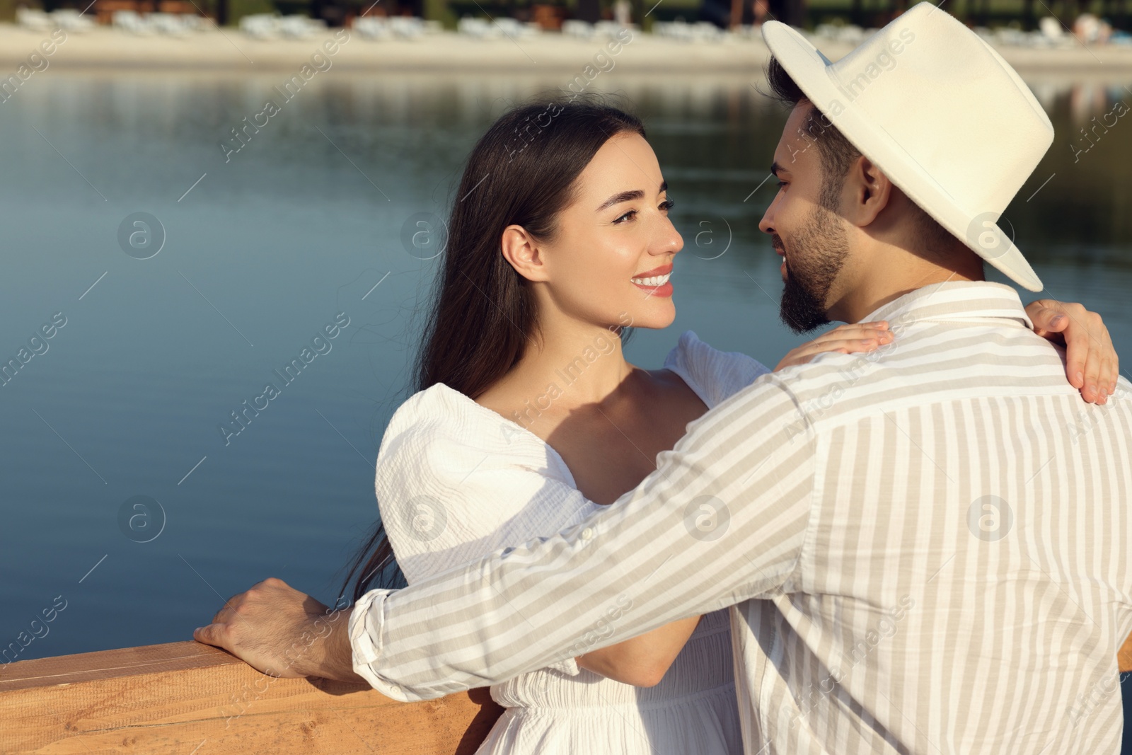Photo of Romantic date. Beautiful couple spending time together near lake