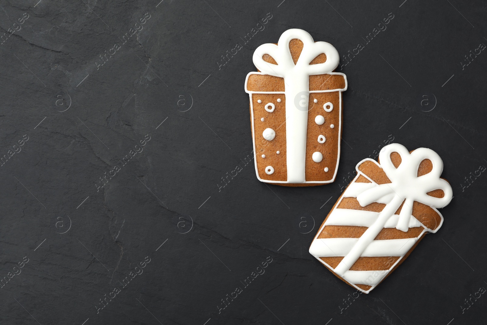 Photo of Gift box shaped Christmas cookies on black table, flat lay. Space for text