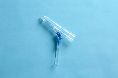 Photo of Anoscope on light blue background, top view. Hemorrhoid treatment