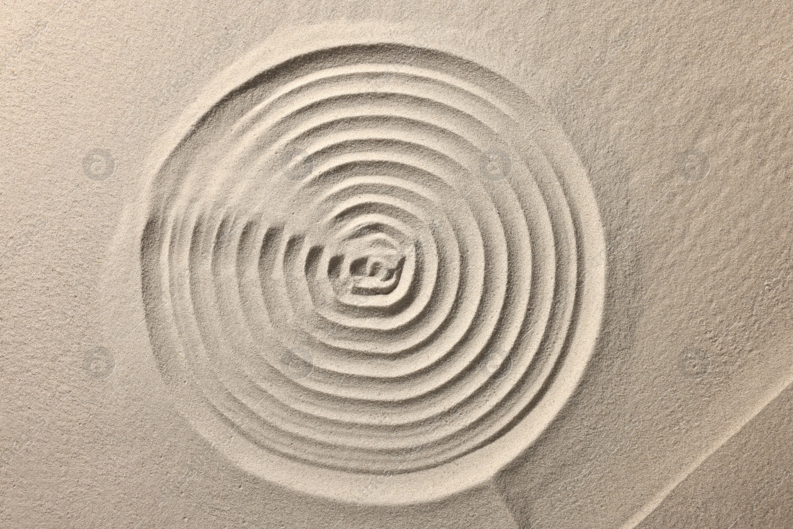 Photo of Beautiful spiral on sand, top view. Zen garden