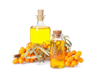 Photo of Natural sea buckthorn oil and fresh berries on white background