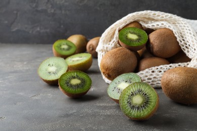 Cut and whole fresh ripe kiwis on grey table