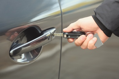 Photo of Closeup view of man opening car door with key