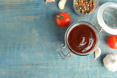 Photo of Flat lay composition with barbecue sauce on blue wooden table. Space for text