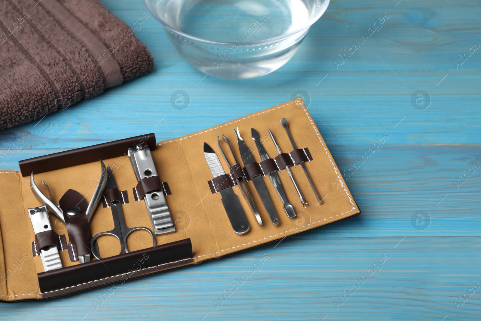 Photo of Manicure set in case on light blue wooden background