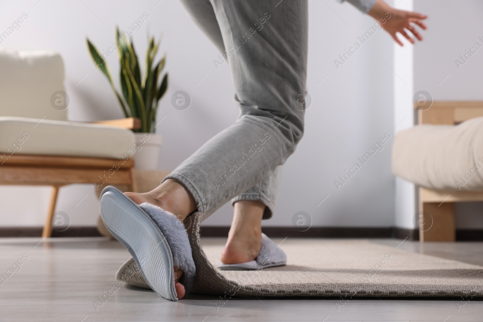 Photo of Woman tripping over carpet at home, closeup