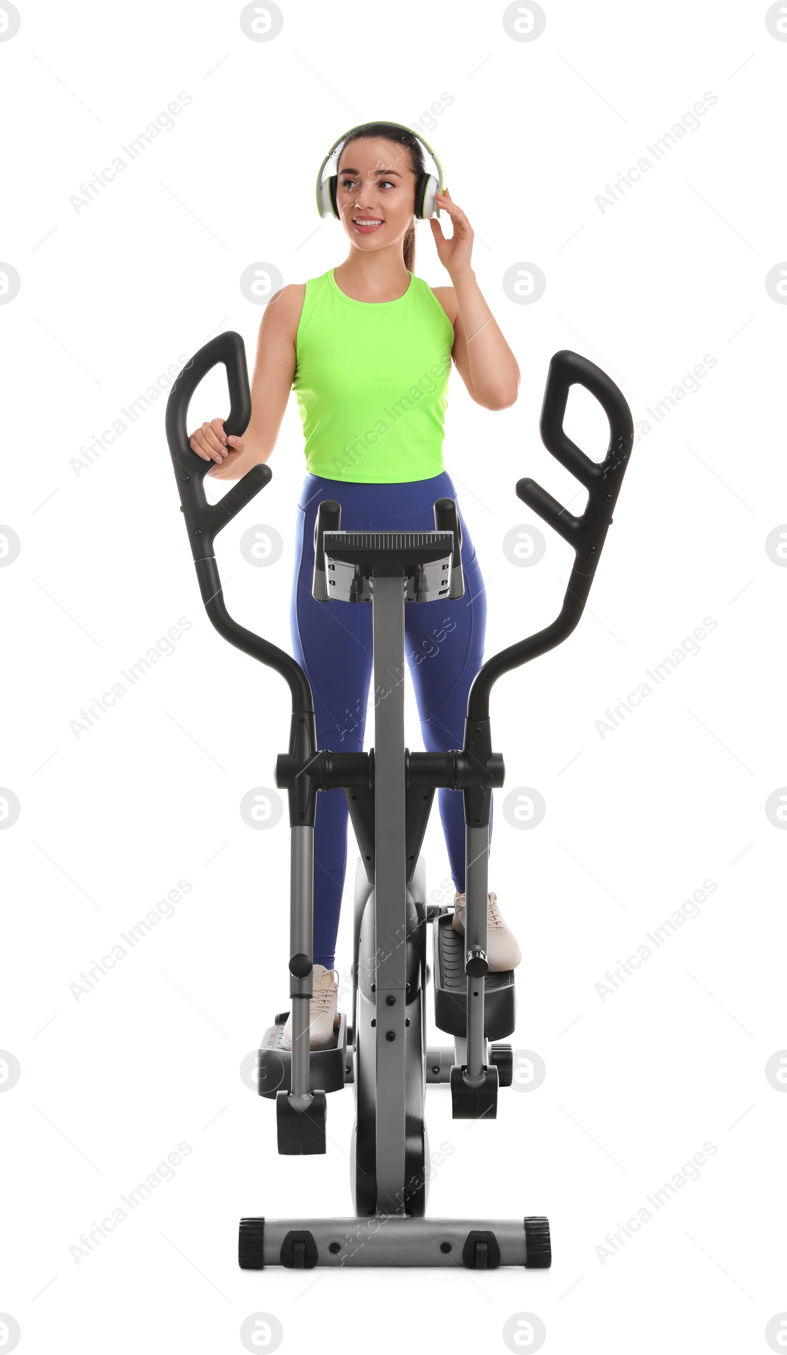 Photo of Woman with headphones using modern elliptical machine on white background