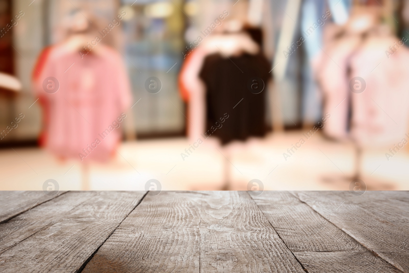 Image of Empty wooden table and blurred view of store with modern clothes