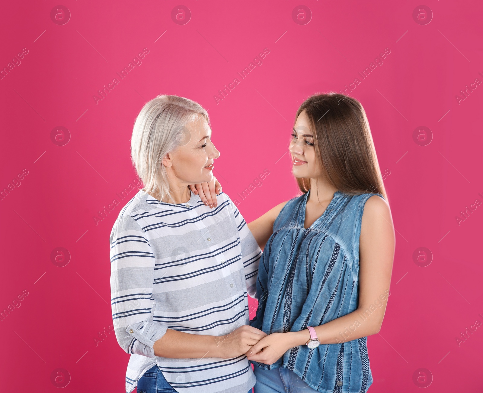 Photo of Portrait of young woman with her mature mother on color background