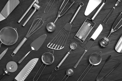 Cooking utensils on black table, flat lay