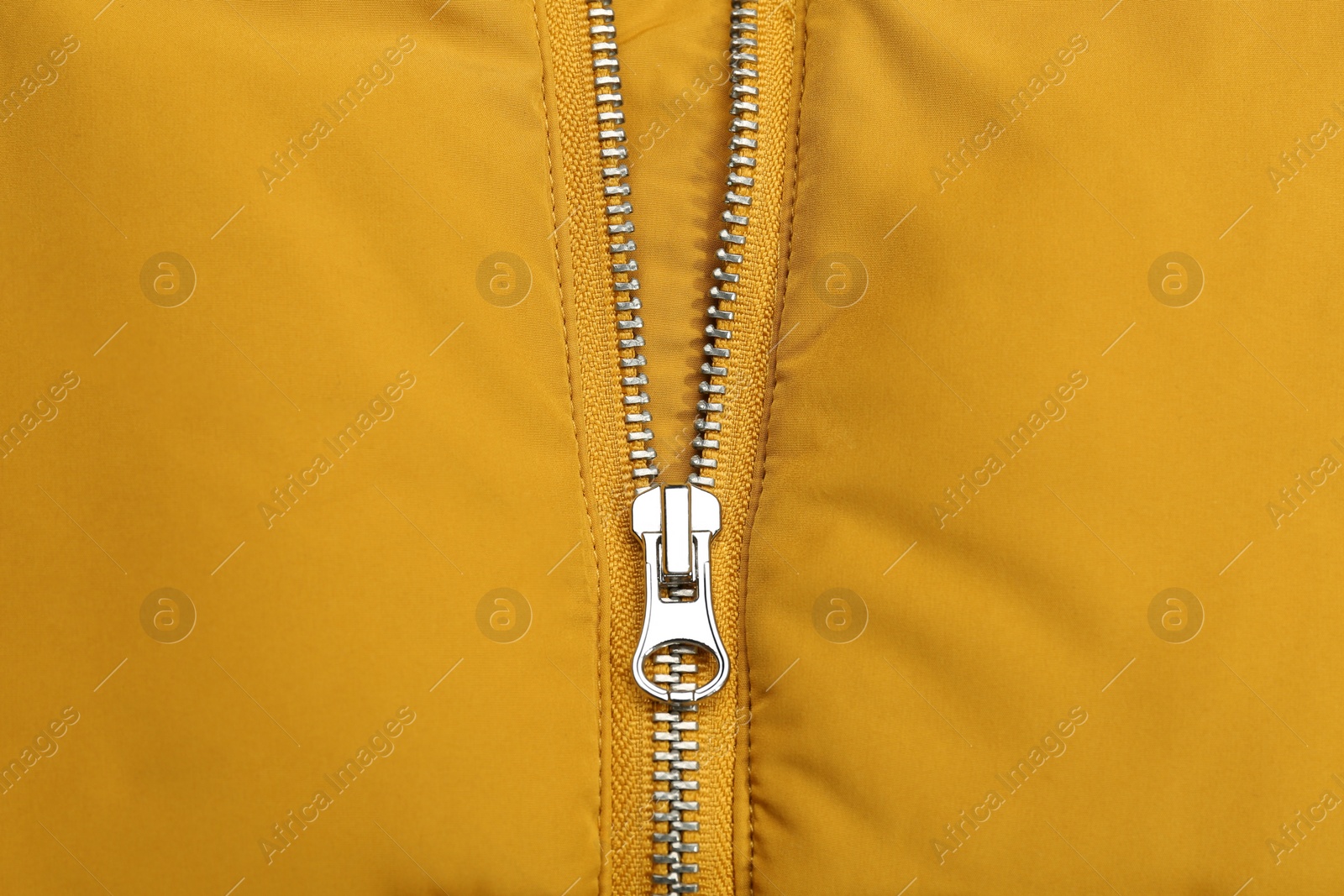 Photo of Yellow jacket with zipper as background, top view