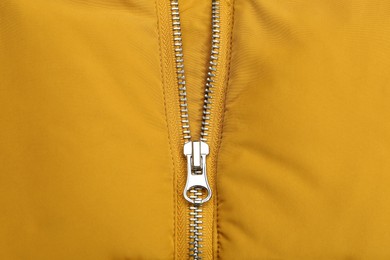 Photo of Yellow jacket with zipper as background, top view