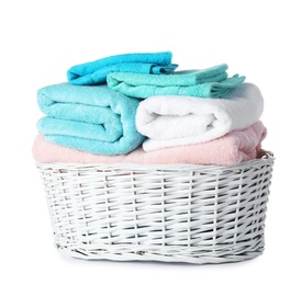 Wicker laundry basket with clean towels on white background