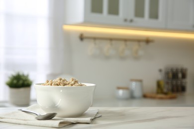 Breakfast time. Tasty oatmeal in bowl on white marble table. Space for text
