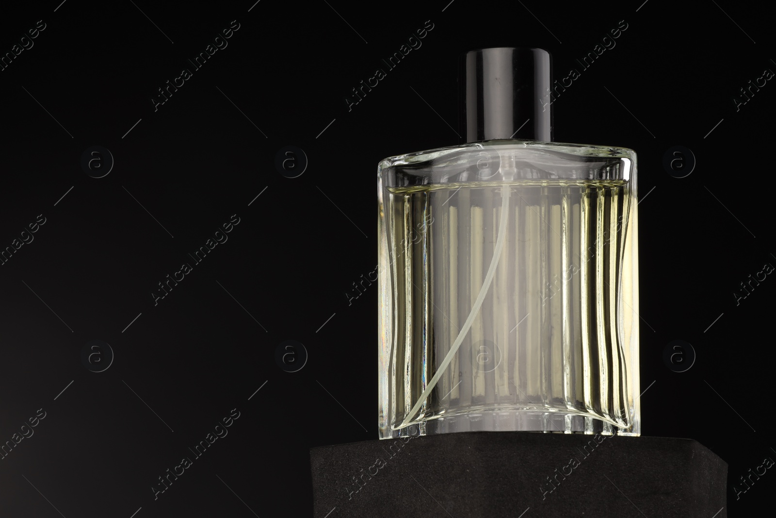 Photo of Luxury men`s perfume in bottle against dark background, space for text