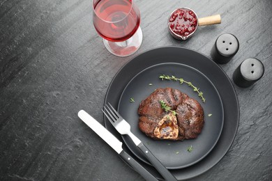 Tasty grilled beef meat served on black table, flat lay. Space for text