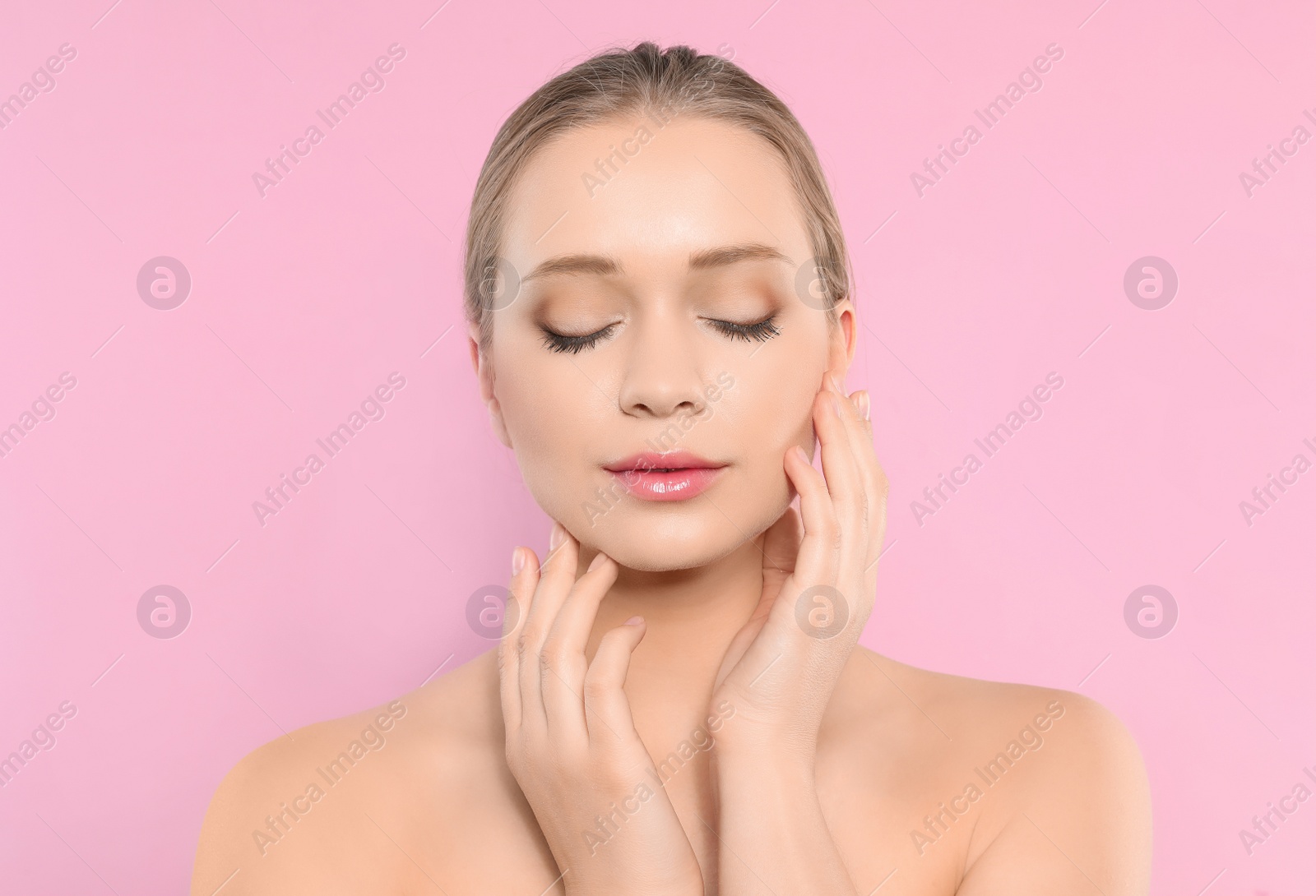 Photo of Portrait of young woman with beautiful face on pink background