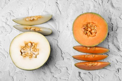 Photo of Tasty colorful ripe melons on white textured background, flat lay