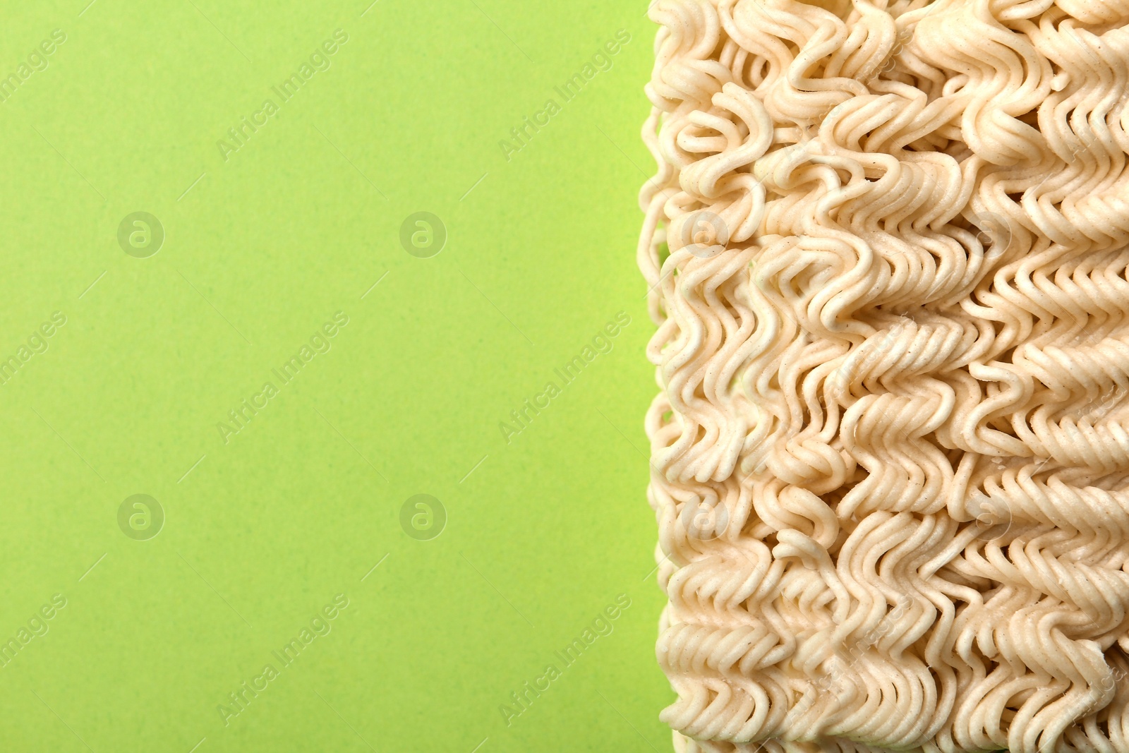 Photo of Block of quick cooking noodles on color background, top view. Space for text