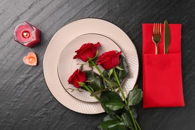 Photo of Place setting with candles and roses on grey textured table, flat lay. Romantic dinner