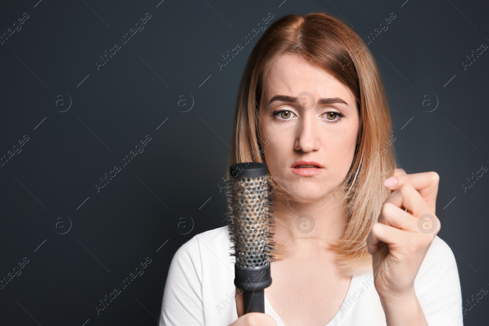 Photo of Young woman with hair loss problem on gray background