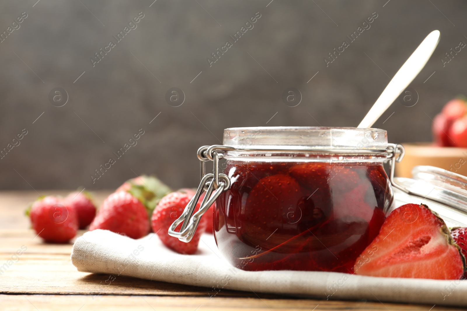 Photo of Delicious pickled strawberry jam and fresh berries on wooden table