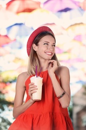 Beautiful woman with tasty drink on city street