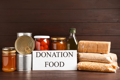 Card with words Donation Food and different products on wooden table