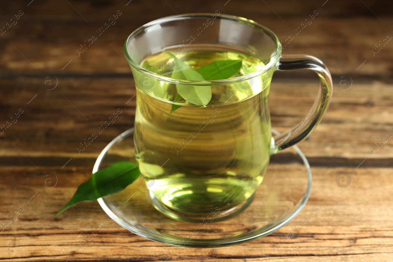 Photo of Cup of aromatic green tea on wooden table