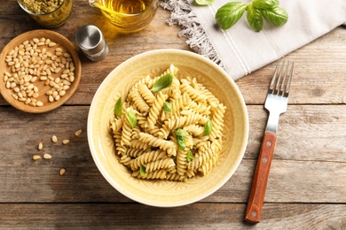 Photo of Plate of delicious basil pesto pasta served for dinner on table, flat lay