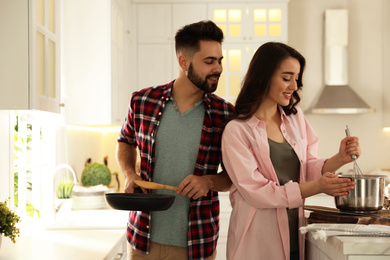 Lovely young couple cooking together in kitchen